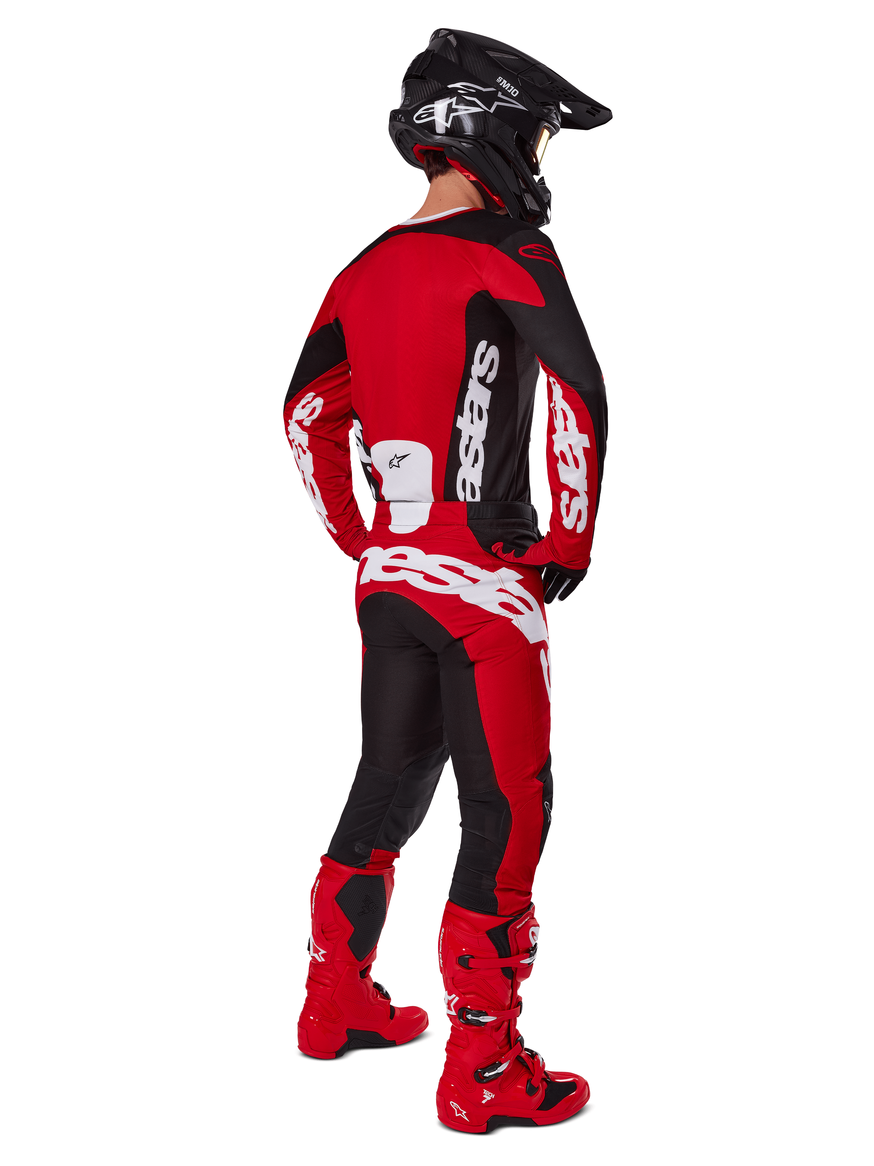 Motocross-Fahrer in der Rückansicht mit dem Alpinestars 2025 Racer Veil Trikot in Schwarz und Hellrot, dazu passende rot-schwarze Hose und rote Motocross-Stiefel, großes weißes Branding, ideal für Offroad-Performance