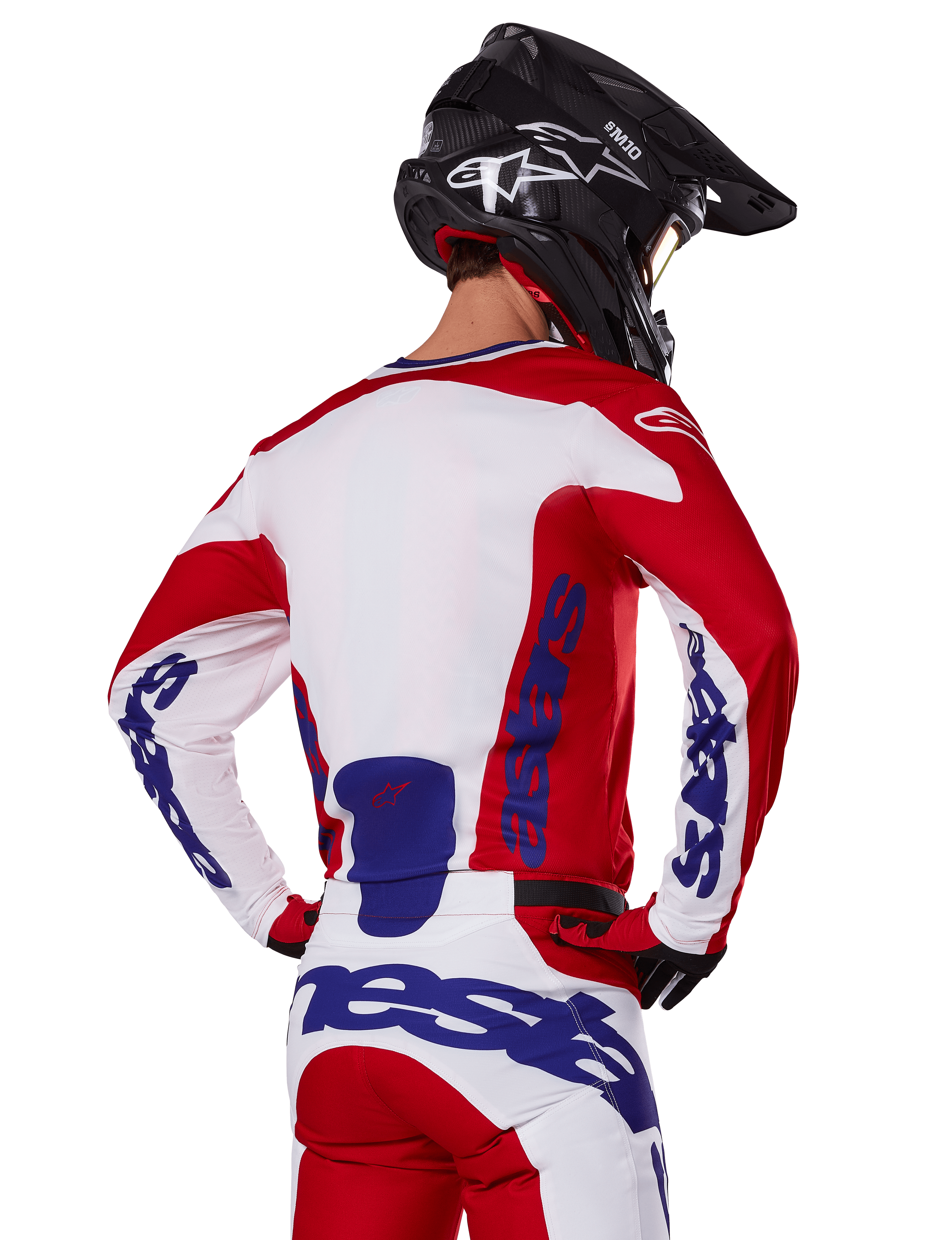 Alpinestars 2025 Racer Veil Jersey and Pants, Motocross Gear Set, Bright Red White and Blue, rear view of rider wearing matching gear and black motocross helmet, featuring bold blue Alpinestars branding, technical off-road racing apparel