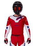 Alpinestars 2025 Racer Veil Jersey, Motocross Racing Jersey, Red White and Blue, Long Sleeve, worn with black helmet and orange goggles, matching red gloves and pants, sleek performance design for off-road riding