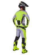 Motocross rider from behind wearing Alpinestars 2025 Racer Veil Gear Set, Gray and Yellow Fluo jersey and pants, matching fluo yellow boots and black and yellow helmet, coordinated outfit for off-road racing