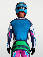 Alpinestars Techstar Maven Trikot, Motocross-Renntrikot in Blau und Grün mit pinken Details, Rückansicht am Model mit Helm, lasergeschnittene Belüftung
