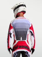 Alpinestars Techstar Maven Trikot, Motocross-Renntrikot, Rot und Weiß, atmungsaktives Gewebe, Rückansicht am Fahrer.