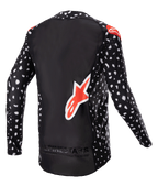 Alpinestars 2023 Supertech North Jersey, Motocross-Trikot, Schwarz mit weißem Sprenkelmuster und neonroten Akzenten, Rückansicht mit großem rotem Alpinestars-Logo und Branding am unteren Saum, professionelle Offroad-Rennausrüstung.