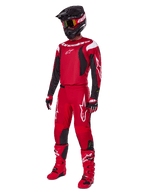 Motocross rider wearing Alpinestars 2025 Fluid Haul Gear Set, Bright Red with Black and White accents, complete outfit including jersey, pants, helmet, boots, and gloves, designed for off-road performance and protection