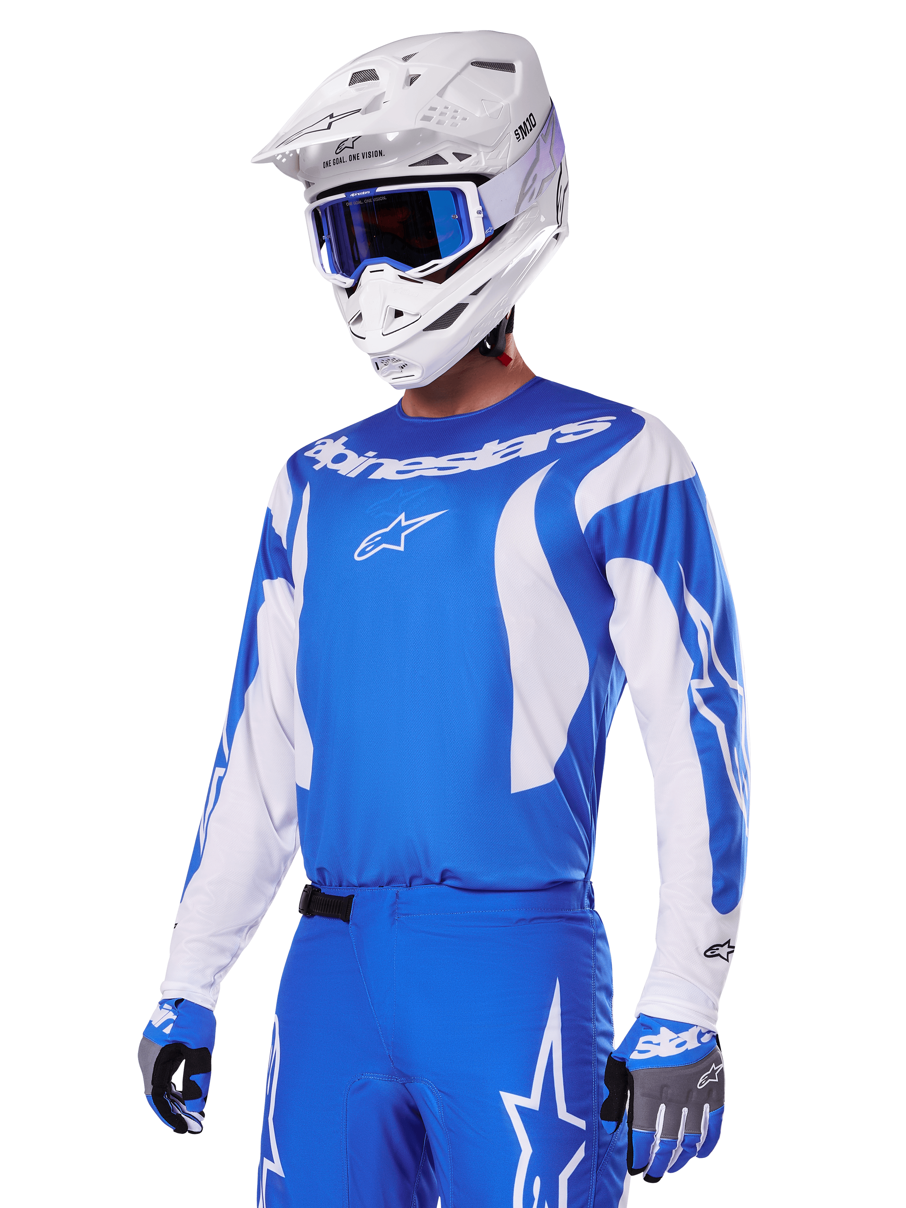 Motocross-Fahrer im Alpinestars 2025 Fluid Haul Gear Set in Blau und Weiß, bestehend aus einem blauen Jersey mit weißen Akzenten, passender blauer Hose mit Stern-Logos, weißem Helm mit blauer Goggle und abgestimmten blau-grauen Handschuhen, komplette Offroad-Rennausrüstung.