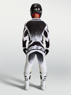 Alpinestars Techstar Swan Trikot und Gear Set, Herren-Motocross-Outfit, Schwarz und Weiß, Rückansicht mit Splatter-Grafiken.