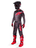 Alpinestars 2025 Supertech Lipan Gear Set, vollständige Motocross-Rennausrüstung, dunkelgraues und rotes Trikot mit großem Sternlogo, passende Hose mit roten Akzenten und Sternengrafiken, rote Handschuhe, leuchtend rote Stiefel mit weißen Schnallen, mattschwarzer Helm mit roter Brille