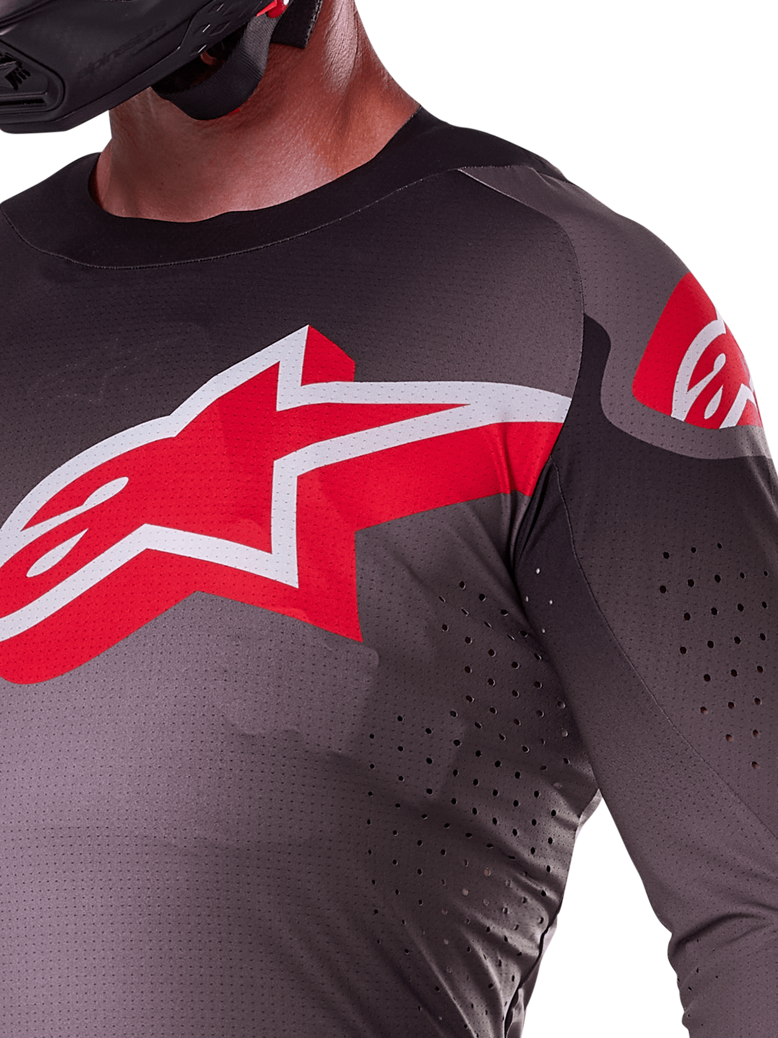 Alpinestars 2025 Supertech Lipan Trikot, Smoke Bright Red, Nahaufnahme des großen rot-weißen Stern-Logos auf der Brust, lasergeschnittene Perforationen für Luftzirkulation, leichtes atmungsaktives Material an einem Fahrer.