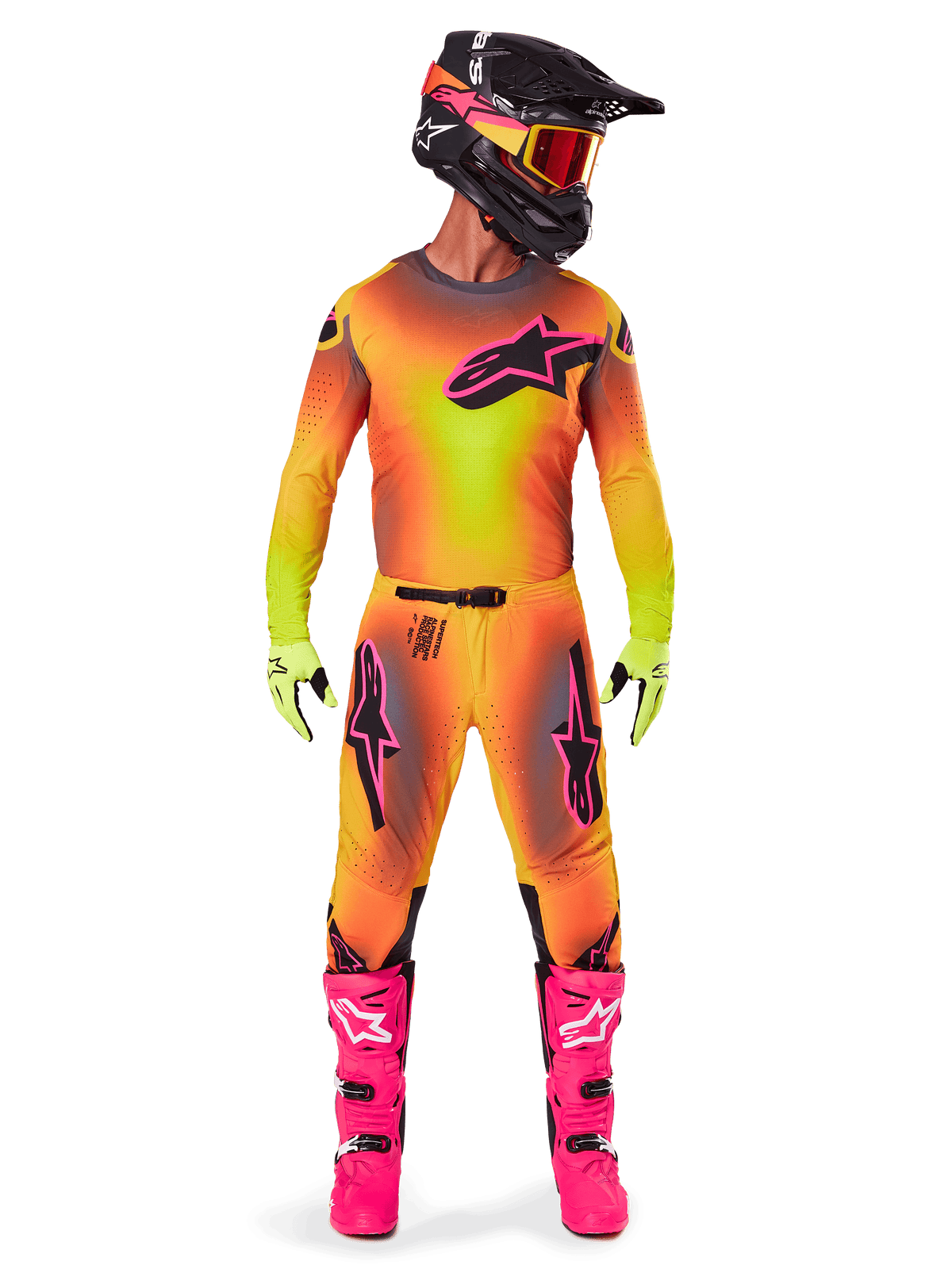 Motocross-Fahrer in kompletter Rennausrüstung, 2025 Supertech Lipan Trikot und Hose mit gelb-orangefarbenem Farbverlauf und pinken Akzenten, schwarzer Helm mit passenden pinken Grafiken, leuchtend pinke Stiefel und neongrüne Handschuhe, abgestimmtes Alpinestars Offroad-Rennoutfit.