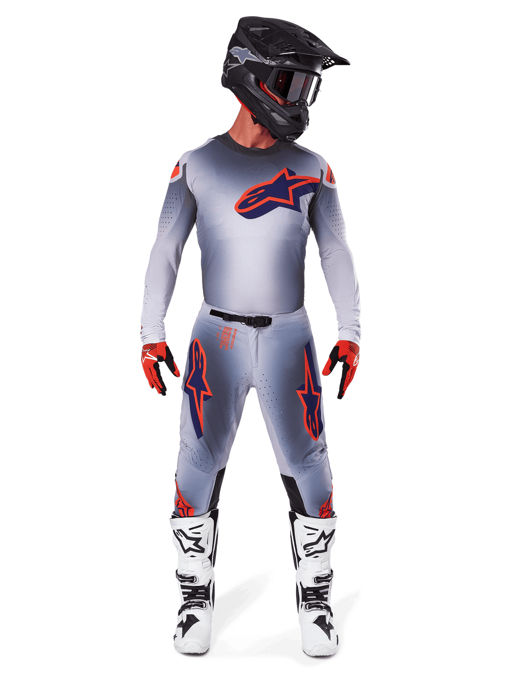 Motocross-Fahrer im Alpinestars 2025 Supertech Lipan Jersey in Grau Orange Fluo, mit grauem Farbverlauf und orangefarbenem Logo, kombiniert mit passender Motocross-Hose, schwarzem Helm, weißen Stiefeln und orangefarbenen Handschuhen, abgestimmte Profi-Rennausrüstung.