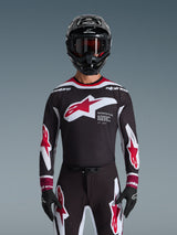 Alpinestars 2026 Supertech AFD Vista Jersey, Motocross Jersey in Black Red and White, shown on a rider with a black helmet, goggles, and gloves, featuring a large chest logo and 'SUPERTECH AFD' branding, professional racing gear for off-road performance
