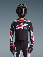 Alpinestars 2026 Supertech AFD Vista Gear Set, Motocross-Komplettausrüstung, schwarzes Jersey mit roten und weißen Logos sowie 'Supertech AFD'-Branding, passende schwarze Hose mit roten Akzenten, schwarzer Helm mit roter Brille, koordiniertes professionelles Rennoutfit