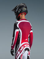 Alpinestars 2026 Supertech AFD Vista Ausrüstungsset, Rückansicht eines Motocross-Fahrers in schwarz-rot-weißer Rennbekleidung, Jersey mit tiefrotem Rückenpanel und athletischer Passform, passende Hose mit markantem Alpinestars-Logo, schwarzer Helm und Handschuhe, professionelles Motocross-Rennoutfit
