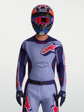 Alpinestars Racer Air Hunt Trikot, atmungsaktives Motocross-Trikot für Herren in Lila und Pink, perforiertes Mesh-Gewebe mit ergonomischer Race-Passform, on-model mit Helm.
