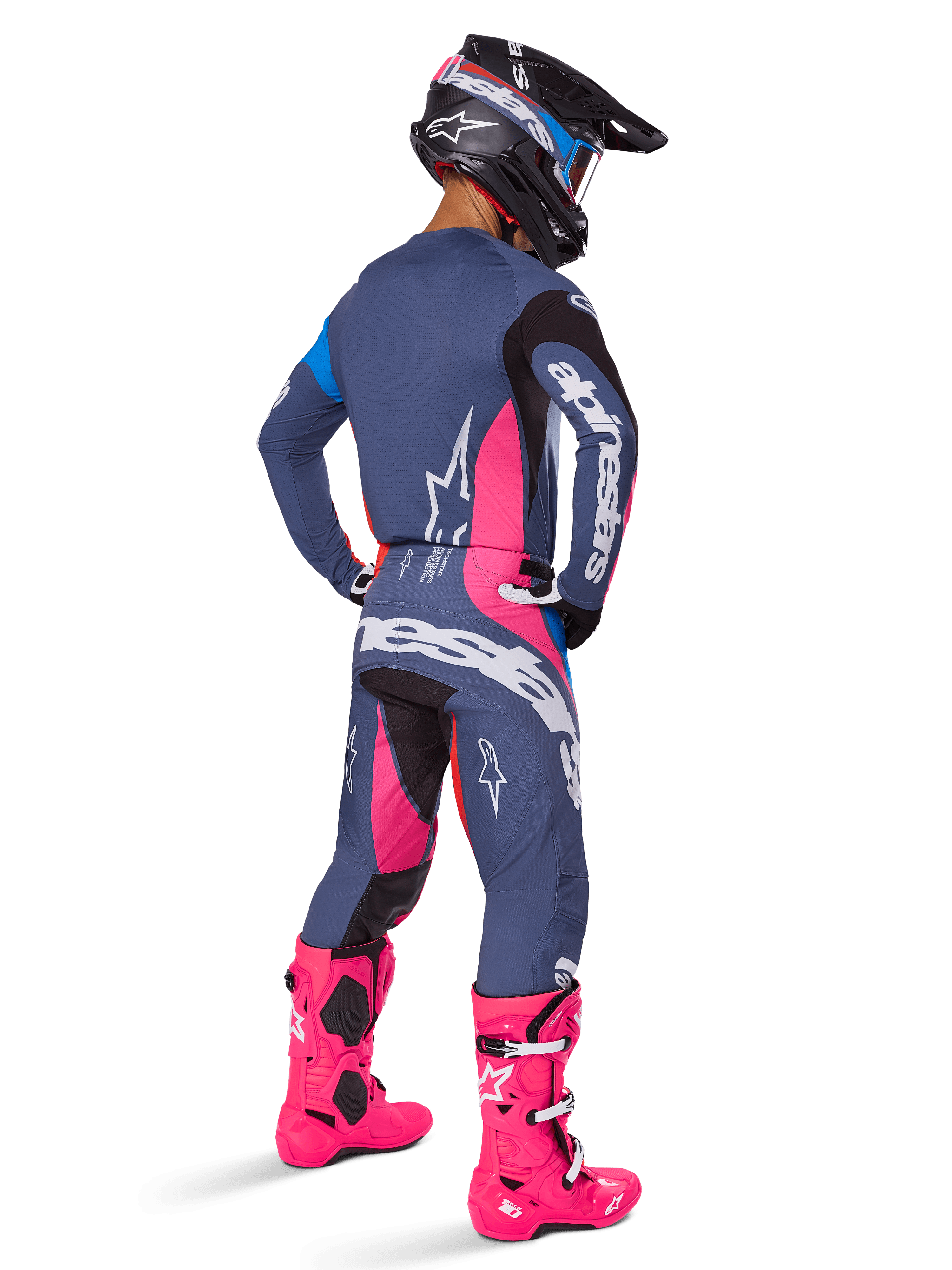 Motocross rider from a rear view, wearing the Alpinestars 2025 Techstar Dreem gear set, Gray with vibrant pink and white accents, black and white helmet, and bright pink boots, complete racing outfit for motocross performance.