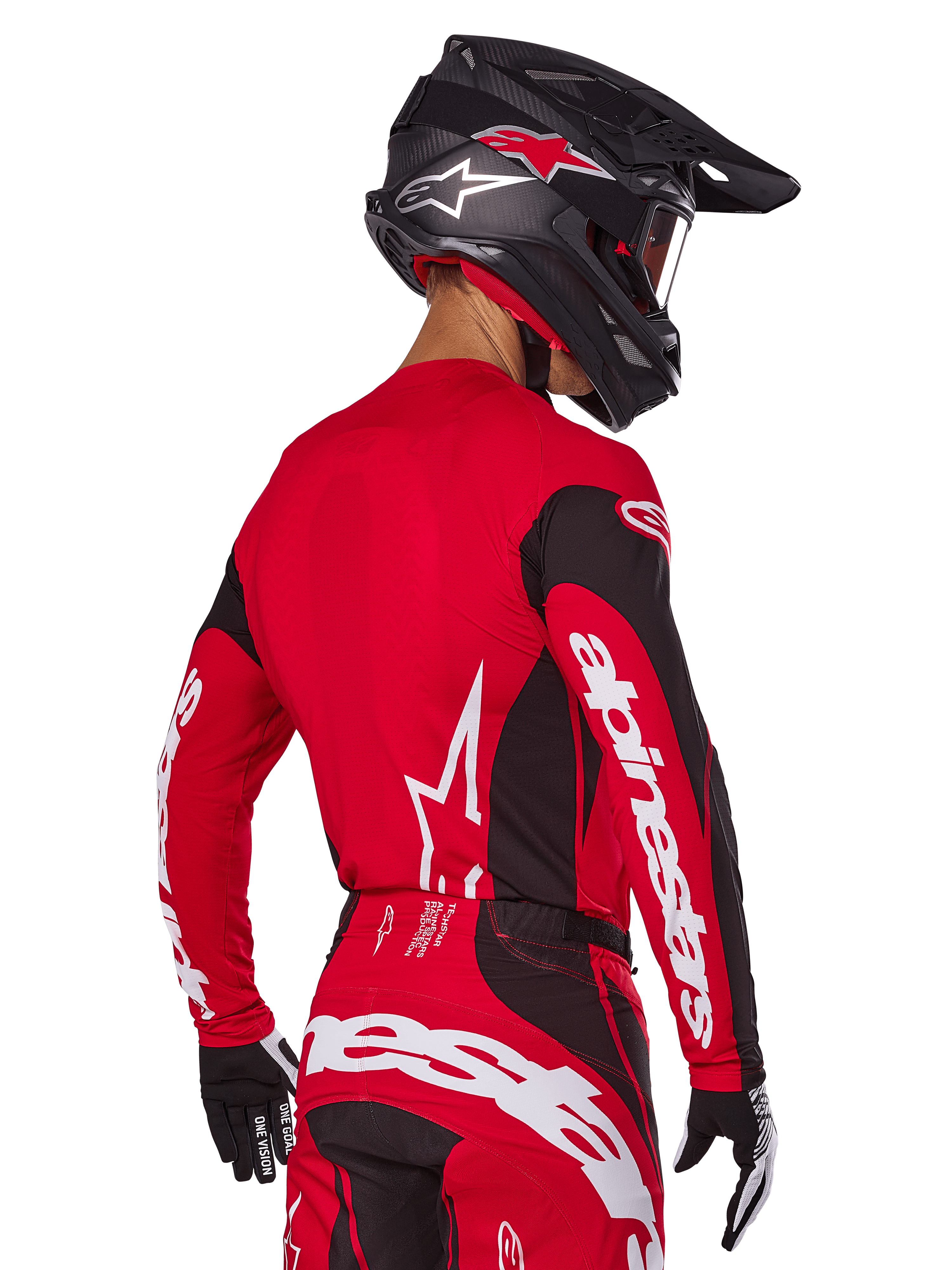Motocross rider from back view wearing Alpinestars 2025 Techstar Dreem Gear Set, Red and black jersey with white sleeve branding, matching red and black pants with bold white logo on the seat, black carbon helmet with red accents, black and white gloves, professional off-road racing outfit.