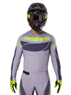 2025 Techstar Dreem Jersey and Gear Set, Motocross racing outfit, light gray and dark gray with neon yellow accents, features 'astars' branding, worn with black helmet, goggles, and matching gloves, technical perforated material for off-road performance