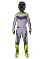 Motocross rider wearing the Alpinestars 2025 Techstar Dreem Gear Set in Gray and Dark Gray with bold neon yellow accents, complete with a matching jersey, pants, neon yellow boots, and a black helmet, designed for professional off-road racing.