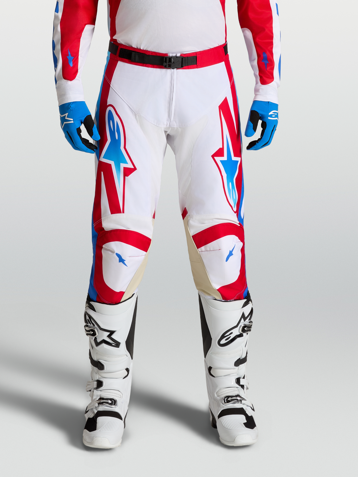 Alpinestars Racer Hose Hunt, Motocross-Hose in Weiß, Rot und Blau, on-model getragen mit Stiefeln, ergonomische Passform und Ziegenleder-Knieeinsätze.