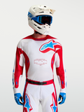 Alpinestars Racer Hunt Trikot, Herren-Motocross-Trikot, Rot und Weiß mit blauen Akzenten, feuchtigkeitsableitendes und belüftetes Mesh, getragen von einem Model mit MX-Ausrüstung.