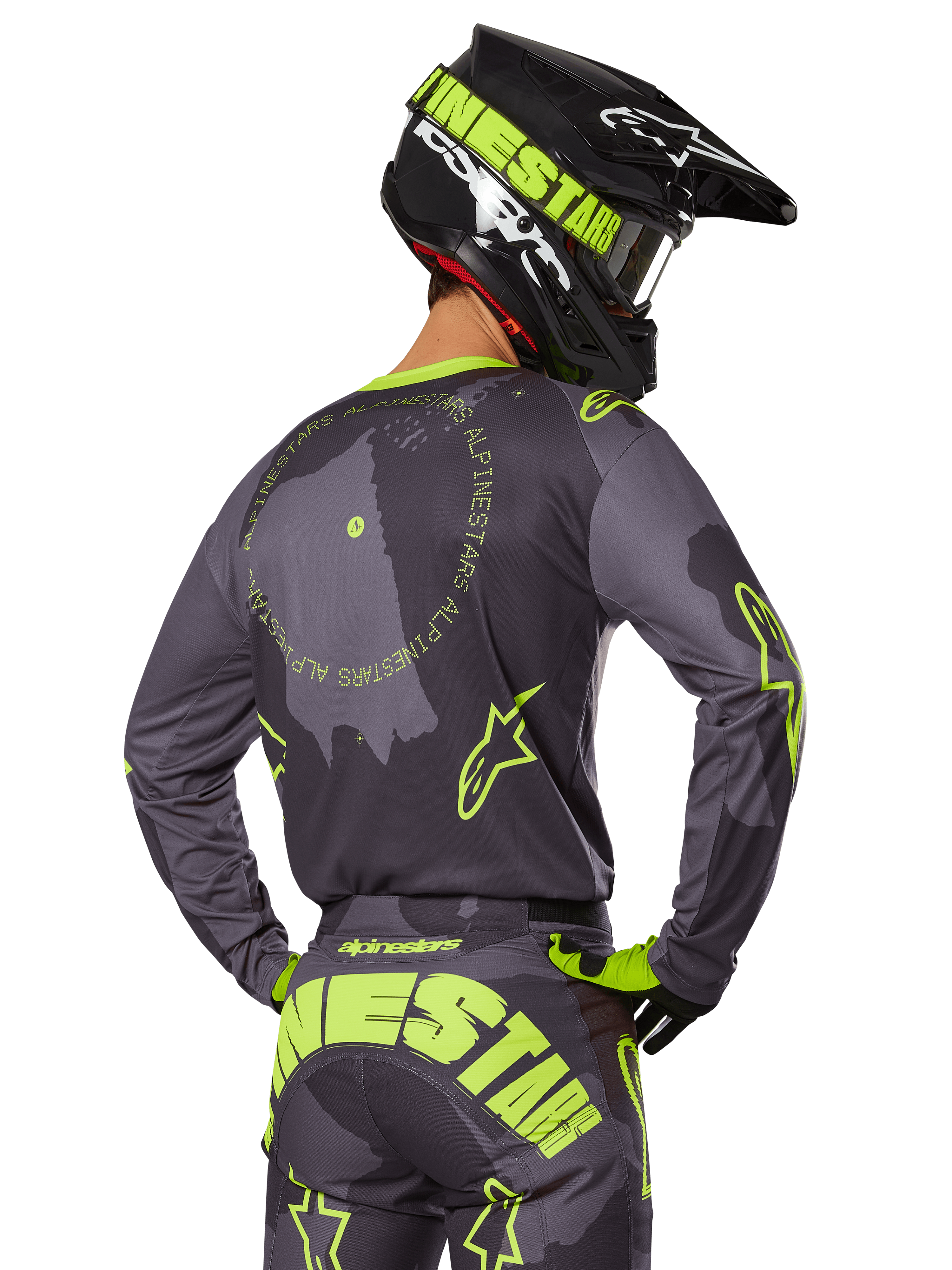 Motocross-Fahrer in der Rückansicht im 2025 Racer Hollow Gear Set, graues Trikot mit neongelbem kreisförmigem Text und Stern-Logos, passende grau-gelbe Hose mit markantem Branding auf dem Gesäß, schwarz-limonengrüner Helm, abgestimmtes Outfit für den Offroad-Rennsport