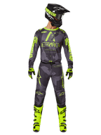 Motocross rider wearing complete racing gear, Alpinestars 2025 Racer Hollow Jersey and matching pants in Dark Camo Yellow Fluo, featuring bold fluorescent yellow graphics on a dark grey camouflage background, paired with matching gloves, bright yellow fluo boots, and a black helmet.
