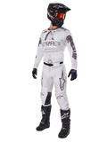 Alpinestars 2025 Racer Hollow Gear Set, Motocross-Outfit, Weiß und Grau, Jersey und Hose mit markantem 'STARS'-Branding, schwarzer Helm mit orange-rot getönter Brille, schwarze Handschuhe und schwarze Stiefel, komplette professionelle Ausrüstung für den Motocross-Sport