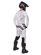 Alpinestars 2025 Racer Hollow Gear Set, Weiß, Rückansicht eines Motocross-Fahrers in weißem Trikot und Hose mit schwarzem Branding, schwarzer Helm und schwarze Stiefel, professionell abgestimmtes Offroad-Rennoutfit