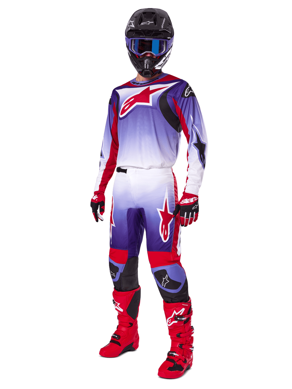 Motocross-Fahrer im Alpinestars 2025 Fluid Wurx Gear Set, lilafarbenes und leuchtend rotes Trikot mit weißen Akzenten, passende Motocross-Hose, leuchtend rote Stiefel, schwarzer Helm mit blauer Brille, rot-schwarze Handschuhe, komplette professionelle Offroad-Rennausrüstung