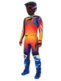 2025 Fluid Wurx Gear Set, Motocross-Jersey und -Hose mit orange-rot-lila Farbverlauf und blau-gelben Sterndesigns, getragen mit schwarzem Helm, roter Brille, rot-schwarzen Handschuhen und blauen Stiefeln, hochsichtbare Rennausrüstung