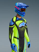 Motocross-Fahrer im 2026 Techstar Nomur Jersey in Dark Navy und Yellow Fluo, kombiniert mit passender Hose, blauem Rennhelm und Goggles, mit großem Alpinestars-Logo und athletischer Rennpassform für Offroad-Performance.