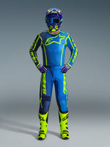 Motocross rider wearing complete racing gear, 2026 Fluid Apex Jersey in Blue and Yellow Fluo, matching pants, neon yellow fluo boots, and a coordinated helmet with blue goggles, professional off-road racing kit