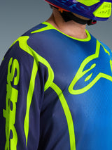 Alpinestars 2026 Fluid Apex Jersey, Motocross Jersey in Blue and Yellow Fluo, close-up view showing the large neon yellow chest logo and sleeve branding, breathable polyfabric construction with ergonomic sport collar