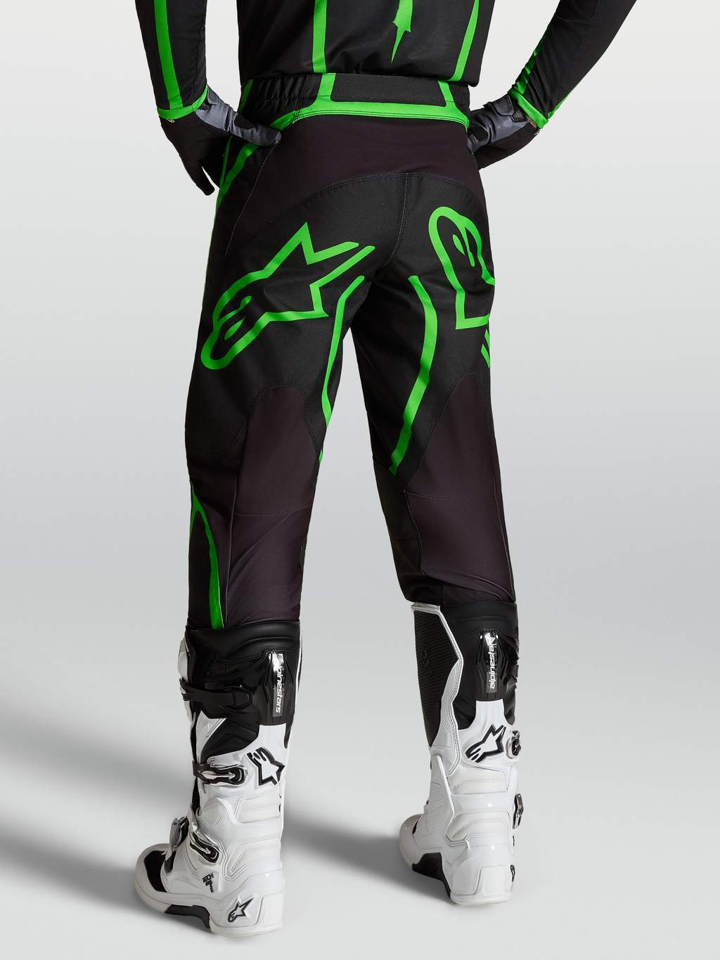 Alpinestars Fluid Apex V2 Hose, Motocross- und Offroad-Hose für Herren, Schwarz und Fluogrün, Rückansicht am Model mit weißen Tech 7 Stiefeln