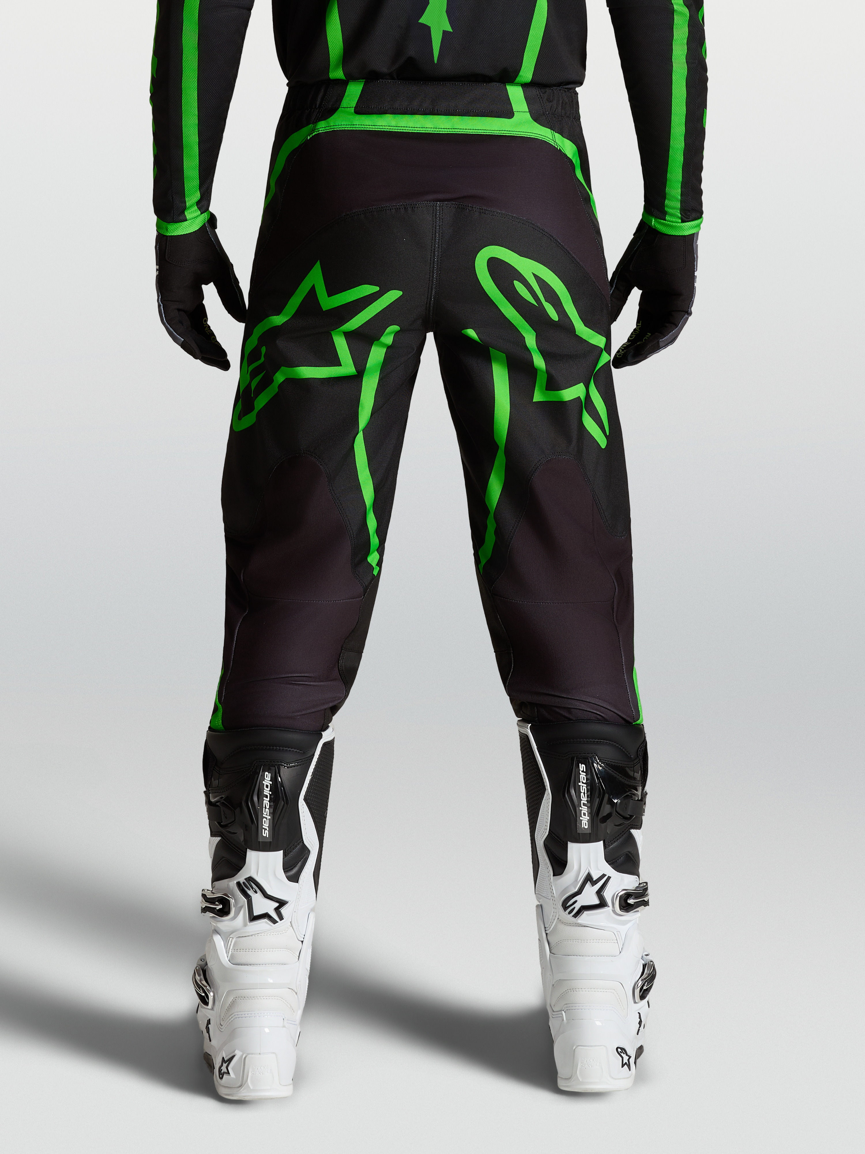 Alpinestars Fluid Apex V2 Hose, Motocross-Hose für Herren, Schwarz und Fluo-Grün, Rückansicht am Model mit großen Stern-Grafiken
