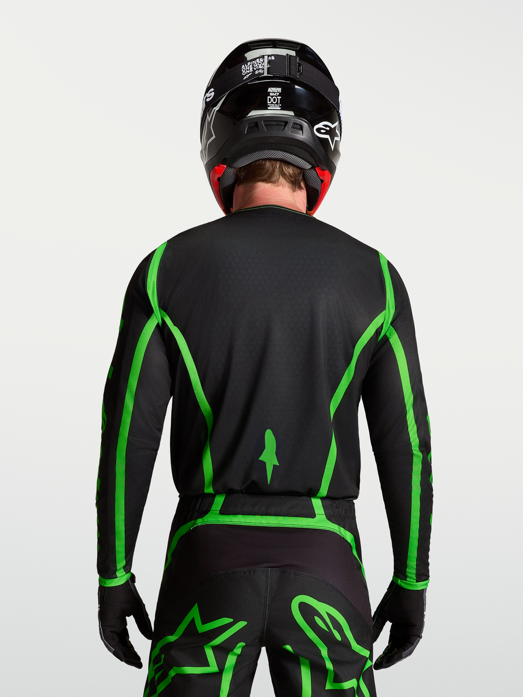 Alpinestars Fluid Apex V2 Jersey for motocross, black and fluorescent green, rear view on model showing extended back coverage.