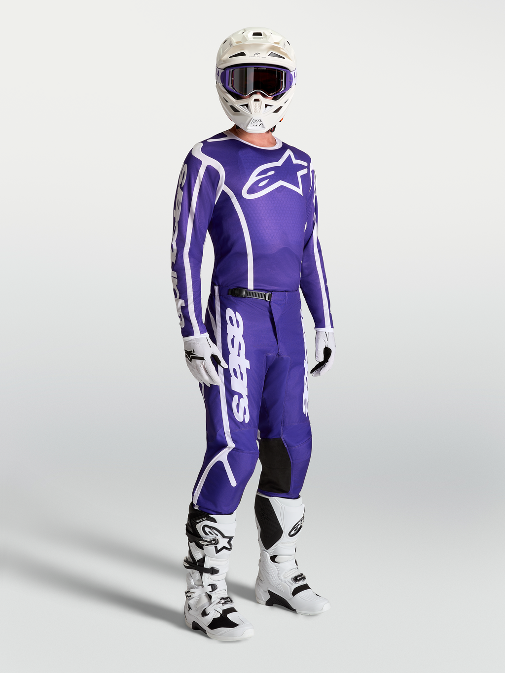 Alpinestars Fluid Apex V2 Trikot und Hose, Motocross-Set in Blau und Weiß, getragen mit weißen Stiefeln und Helm.