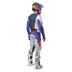Alpinestars 2024 Racer Hoen Hose, Motocross-Ausrüstung, Rückansicht eines Fahrers in voller Montur, Hellgrau, Hot Orange und Schwarz mit violetten Akzenten, sportliches Design für Offroad-Rennen, inklusive Helm, Jersey und weißen Stiefeln