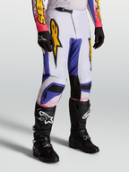 Alpinestars Fluid Drag Hose, Motocross-Hose f1r Herren, Blau und Flieder mit Gold-Grafiken, ergonomisches Sport-Fit-Design, getragen mit schwarzen Stiefeln.
