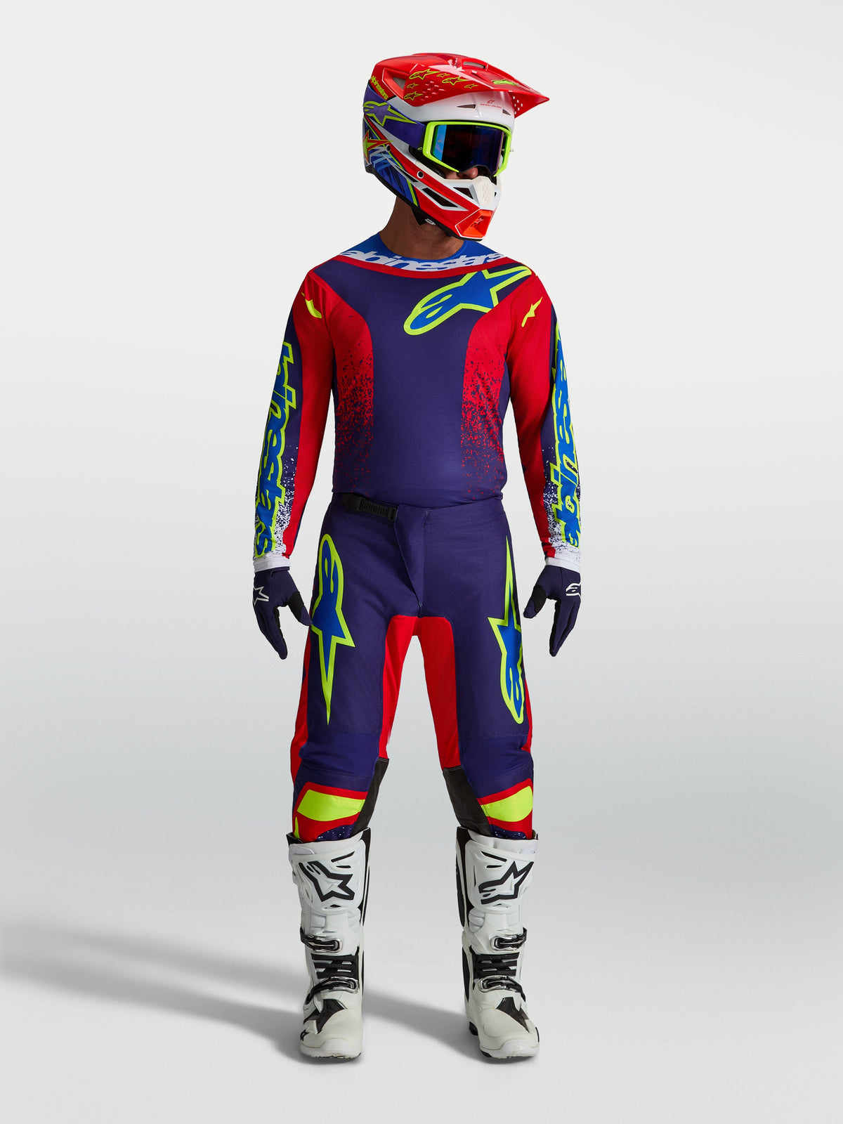 Alpinestars Fluid Drag Trikot und Fluid Drag Ausrüstungsset, Motocross-Outfit in Navy-Blau und Feuer-Rot mit weißen Stiefeln und Helm.