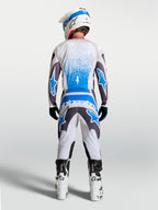 Alpinestars Fluid Drag Trikot, Motocross-Trikot für Herren, Grau und Blau, atmungsaktiv, Rückansicht eines Models in kompletter Offroad-Ausrüstung mit Helm und Stiefeln.