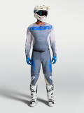 Alpinestars Racer Amber Trikot und Gear Set, Herren-Motocross-Ausrüstung, Aschgrau und UCLA-Blau, mit weißem Helm und Stiefeln.