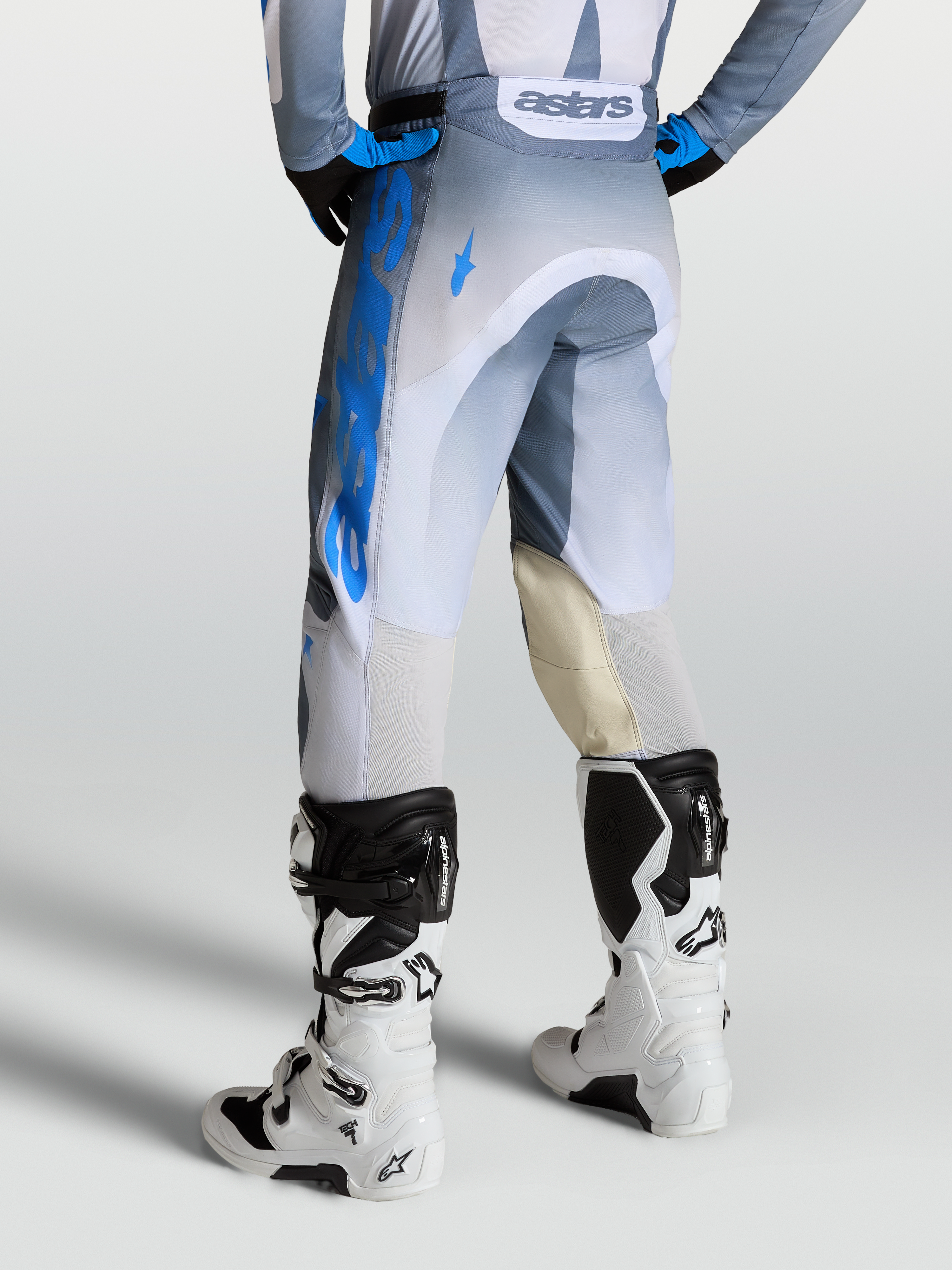 Alpinestars Racer Amber Hose, Motocross-Hose für Herren in Aschgrau und Blau, mit Leder-Knieeinsätzen, Rückansicht an einem Model mit Tech 7 Stiefeln.