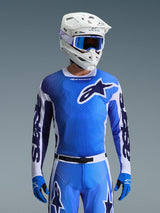 Alpinestars 2026 Racer Air Portl Trikot in Ucla-Blau und Weiß, Motocross-Trikot mit atmungsaktiver Mesh-Konstruktion und markantem Stern-Logo, getragen von einem Fahrer mit passender Hose, weißem Helm und blauer Brille für eine abgestimmte Offroad-Rennausrüstung.