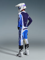 Motocross-Fahrer in der Rückansicht im Alpinestars 2026 Racer Air Portl Trikot in Ucla Blau und Weiß, kombiniert mit passender Motocross-Hose, weißem Supertech Helm und weißen Stiefeln, zeigt ein komplettes, koordiniertes Rennsport-Ausrüstungsset.