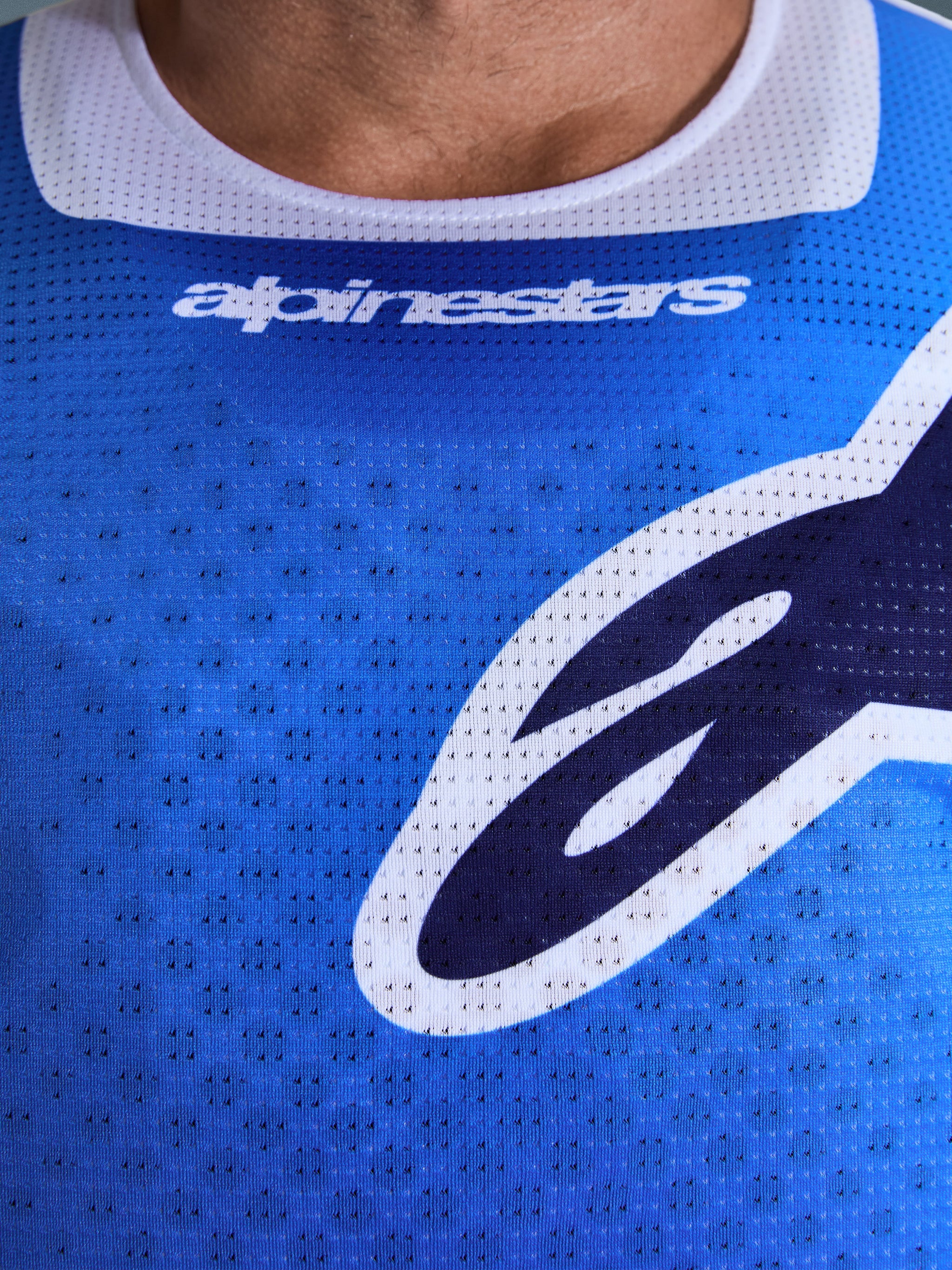 Alpinestars 2026 Racer Air Portl Trikot, Motocross-Trikot, Ucla Blau und Weiß, Nahaufnahme der Brust mit atmungsaktivem perforiertem Mesh-Gewebe, weißem Kragenbesatz und stilisierten Alpinestars-Logos