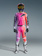 Motocross rider wearing full Alpinestars 2026 Racer Air Portl racing gear, featuring a pink, purple, and orange gradient design on the pants and jersey, paired with a matching helmet, yellow goggles, white boots, and black gloves for a coordinated off-road look.