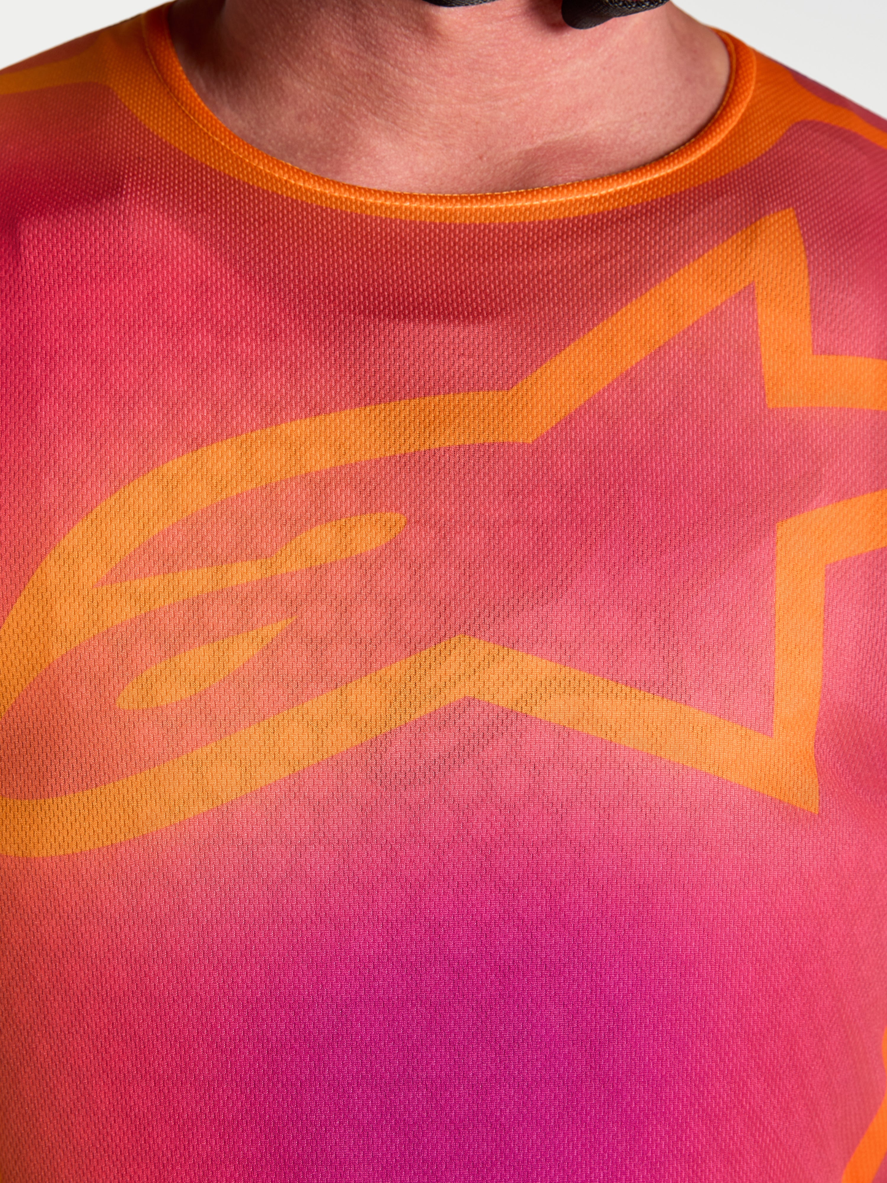Alpinestars Fluid Kepler Trikot, Motocross-Jersey, Lila und Orange, Nahaufnahme des Brustdesigns mit A-star Logo.