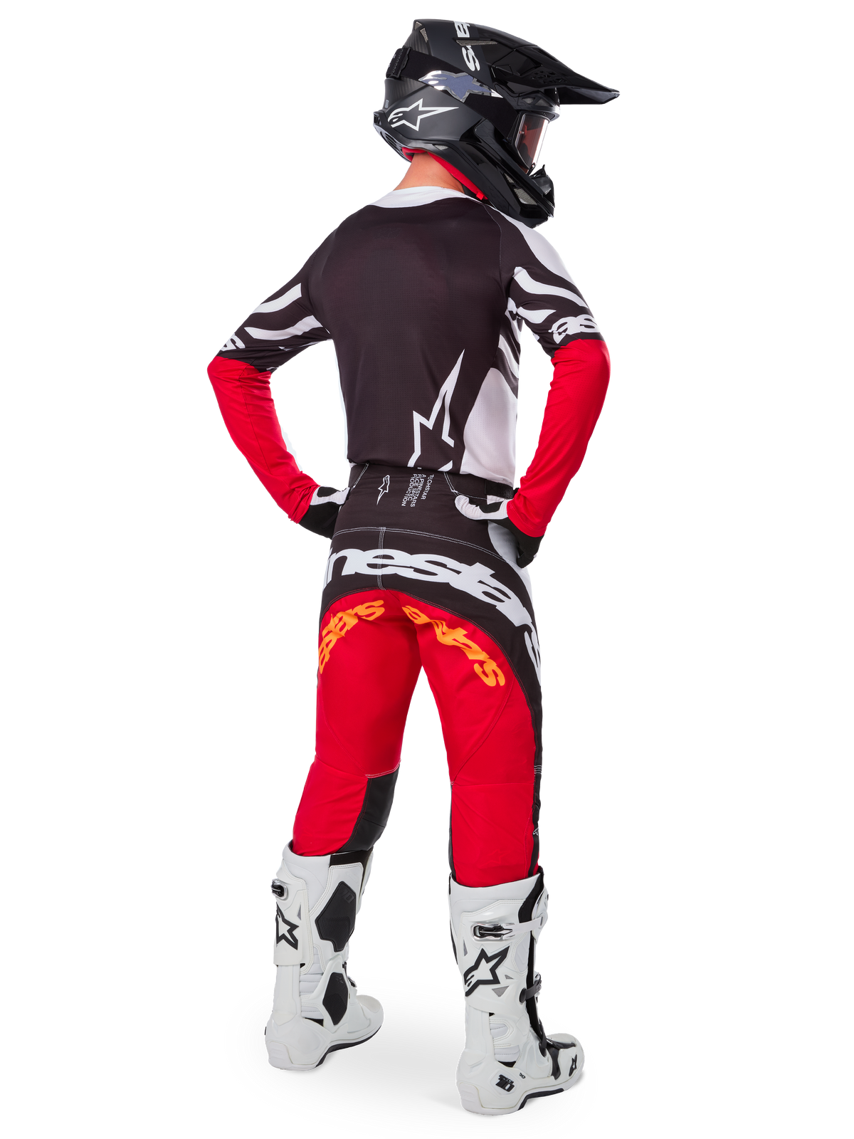 Motocross-Fahrer von hinten im Alpinestars Limited Edition Techstar Deep Trikot in Black White High Red, mit schwarzer Rückseite, weißem Stern-Logo und roten Ärmeln, kombiniert mit einer passenden rot-schwarzen Hose, weiß-schwarzen Stiefeln und einem schwarzen Helm für eine komplette Offroad-Rennausrüstung.