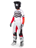 Alpinestars Limited Edition Techstar Deep Gear Set, vollständige Motocross-Rennausrüstung, weißes Trikot mit schwarzen Wellenmustern und roten Ärmeln, weiße Hose mit roten und schwarzen Akzenten, schwarzer Helm mit silberner Brille, weiß-schwarze Handschuhe, weiße Stiefel, abgestimmtes MX-Rennoutfit